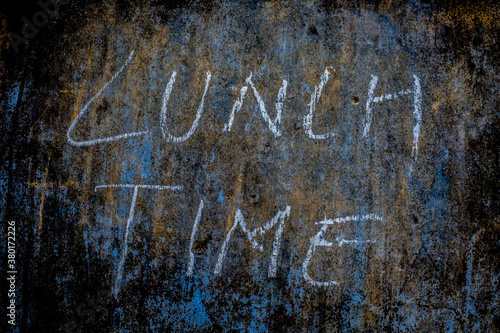 Lunch Time wrote on rough texture wall with white-colored chalk, horizontal shot. photo