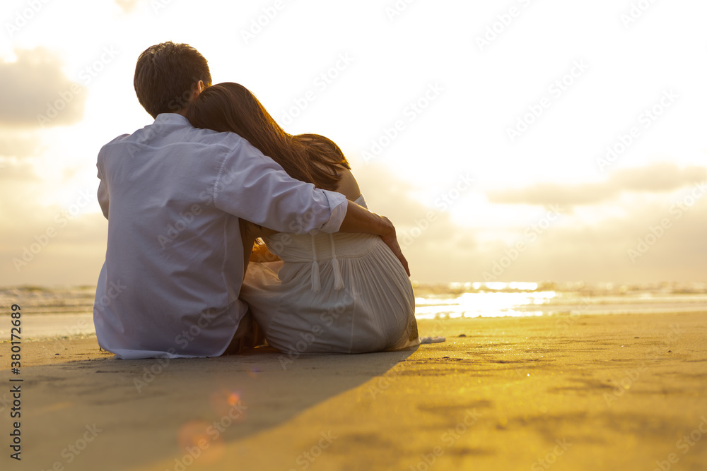 Couple in love watching sunset together on the beach travel summer holidays. People romance concept. Couple in love watching sunset together on the beach travel summer holidays. People romance concept.