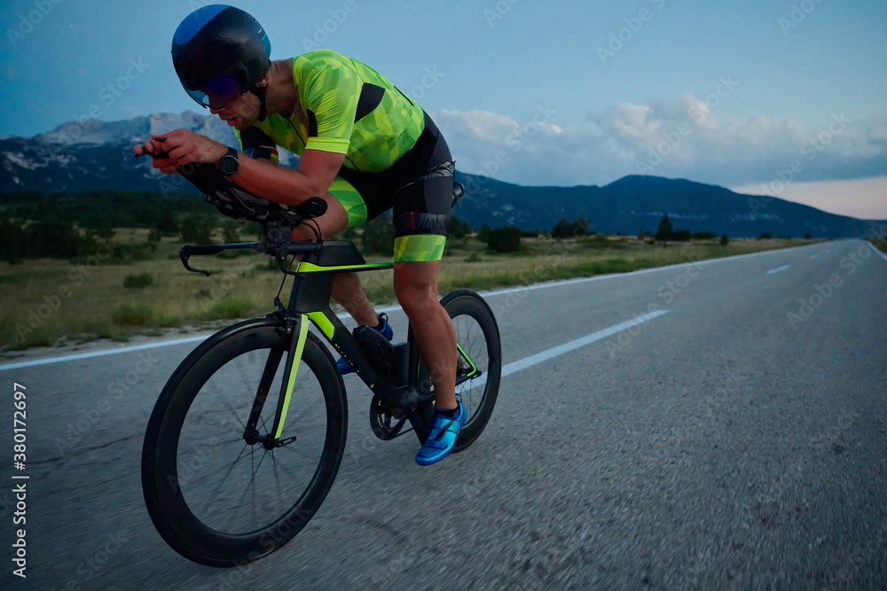 triathlon athlete riding bike at night triathlon athlete riding bike at night