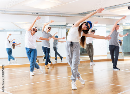 Positive teenage girls and boys training hip hop in dance studio, dance classes for teens
