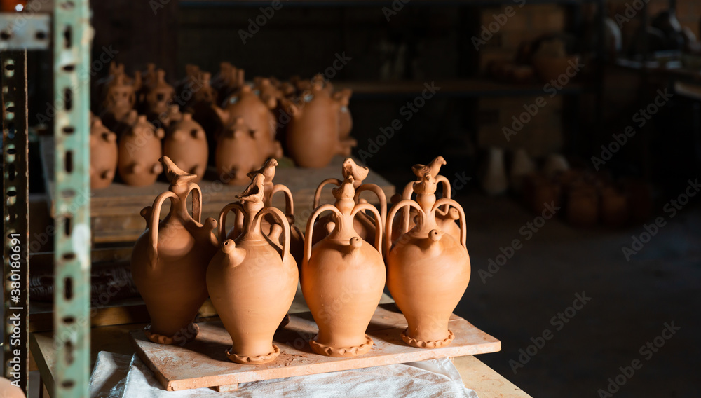 Clay jugs and utensils on racks in store. High quality photo