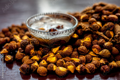 Shot of soapnut or reetha or areetha in a gunny bag along with some of its natural shampoo in a glass bowl. photo