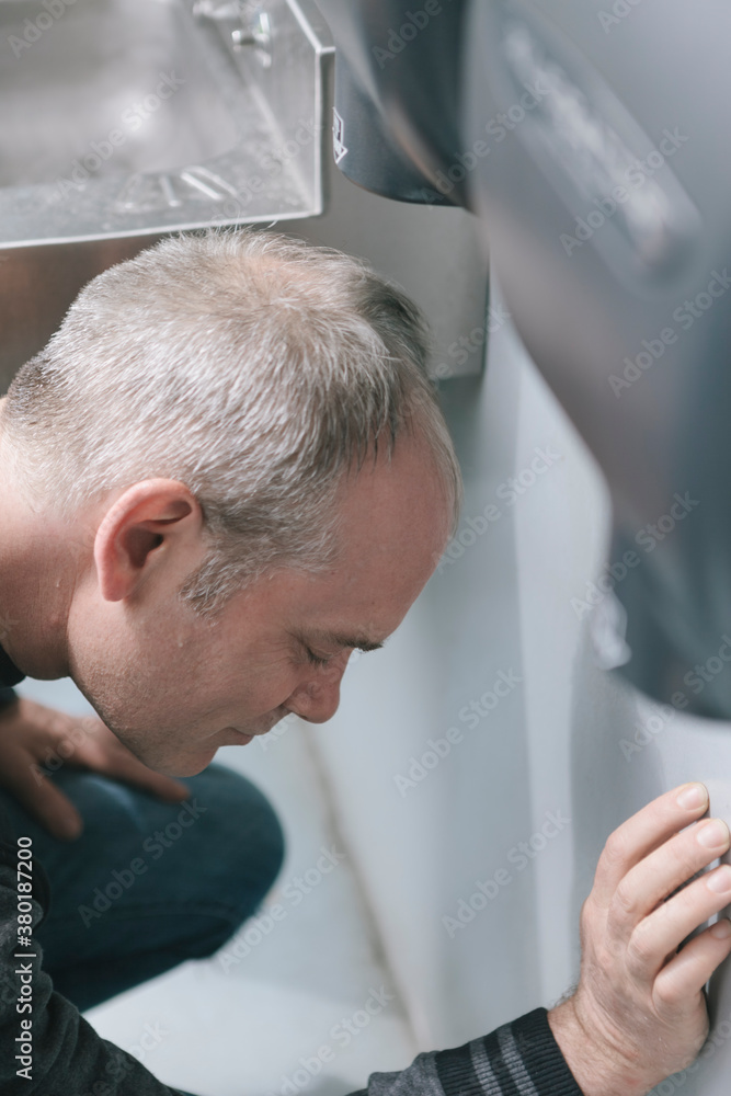 Quirky Man Drying Rain-Soaked Wet Hair in Public Toilet Hand Dryer ...