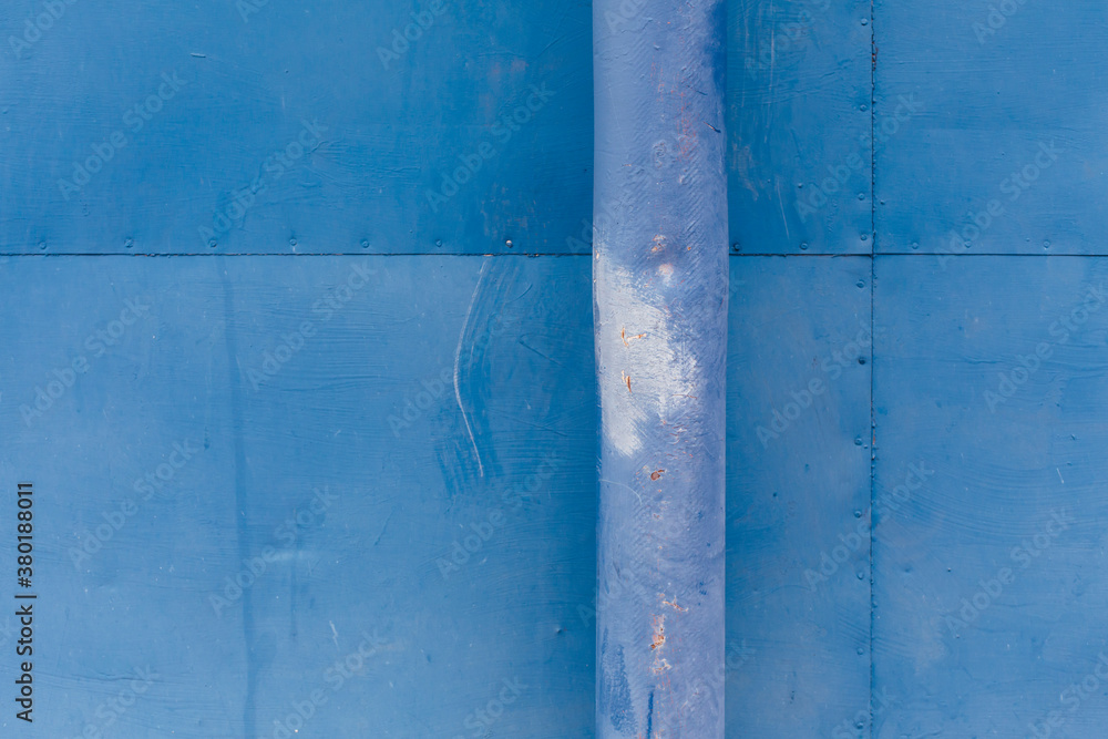 Blue drain pipe and painted metal wall Blue drain pipe and painted metal wall