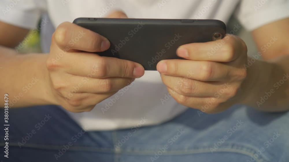 close up man hand using smartphone to playing online game application with feeling excited in relax time , millennial life concept close up man hand using smartphone to playing online game application with feeling excited in relax time , millennial life concept