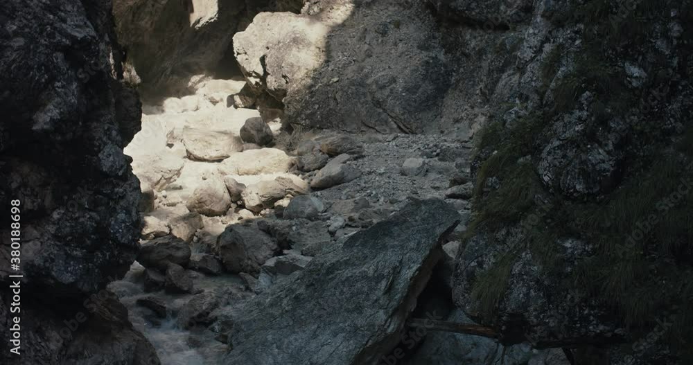 Spring water of wild river in the Alps protected park flowing out of gorge rocks beautiful nature in mountain region lightbeam light slow motion Spring water of wild river in the Alps protected park flowing out of gorge rocks beautiful nature in mountain region lightbeam light slow motion