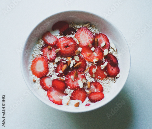 Strawberry breakfast bowl with sliced almonds oatmeal oats and yoghurt photo