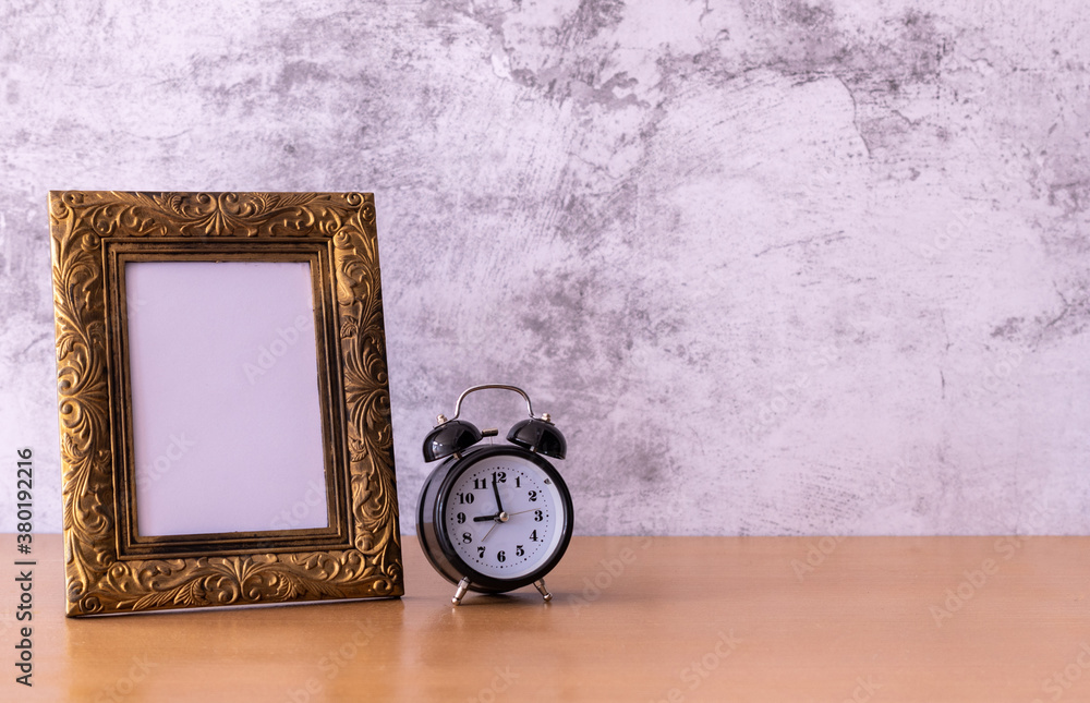 retro style Picture frame and alarm clock on wooden table. Poster product design styled retro style Picture frame and alarm clock on wooden table. Poster product design styled