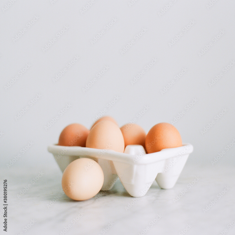Fresh brown eggs in a white porcelain egg crate Fresh brown eggs in a white porcelain egg crate