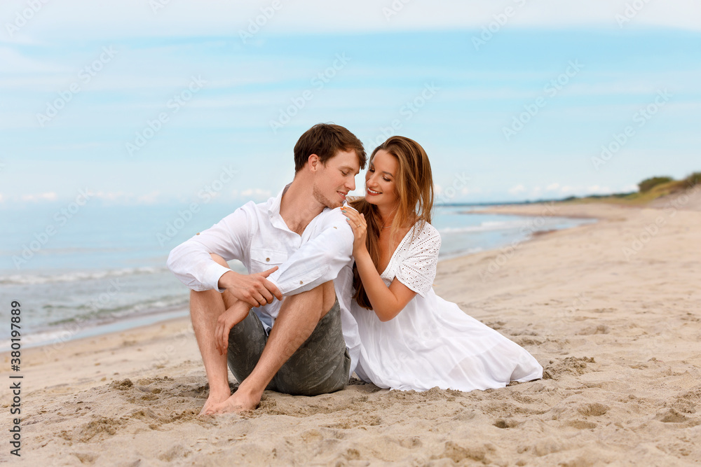 Cute couple of young lovers relax on the sandy beach Cute couple of young lovers relax on the sandy beach
