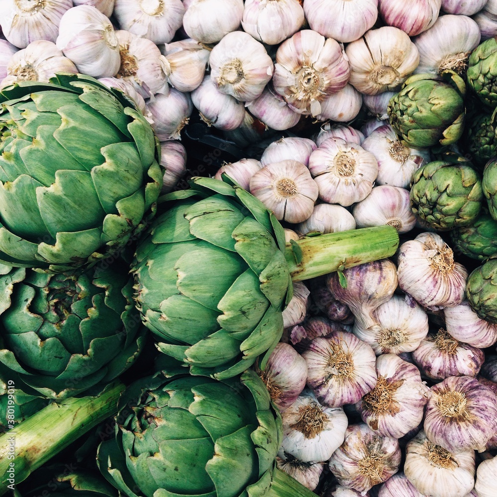 Artichokes and garlic at an outdoor food market Artichokes and garlic at an outdoor food market