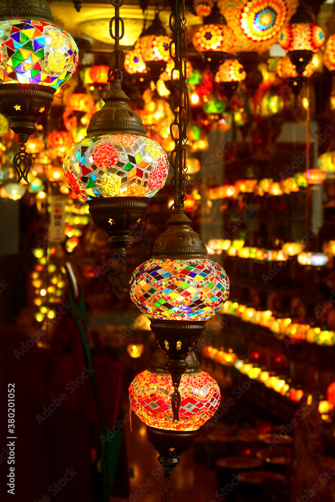 Vertical Image of Arabian Style Multi-color Mosaic Hanging Lamps in a Dark Room