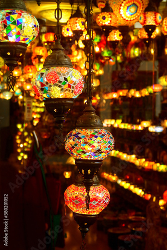 Vertical Image of Arabian Style Multi-color Mosaic Hanging Lamps in a Dark Room © jobi_pro