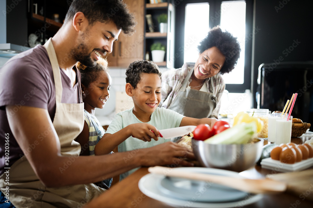 Happy african american family preparing healthy food together in kitchen Happy african american family preparing healthy food together in kitchen