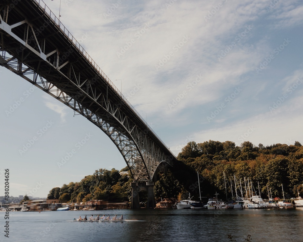 a rowing crew paddling under a bridge and through a canal in the morning a rowing crew paddling under a bridge and through a canal in the morning