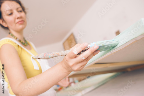 Artist at work painting big canvas in her studio. photo