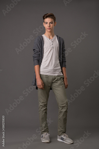 Handsome teen guy in grey cardigan and white tank top