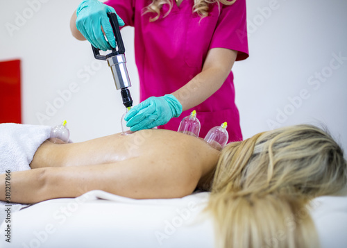 View of a young woman getting a  ventosa massage in a spa salon photo