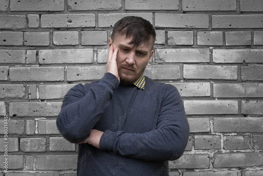 Man on the background of a wall of white bricks. Man on the background of a wall of white bricks.