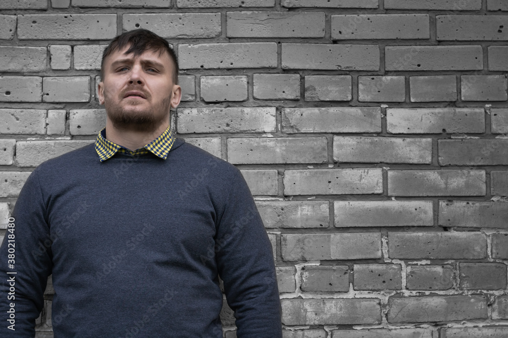 Man on the background of a wall of white bricks. Man on the background of a wall of white bricks.