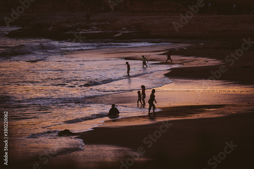 A group of beach goers enjoy the last bits of sunshine and tide as the days nears an end. photo