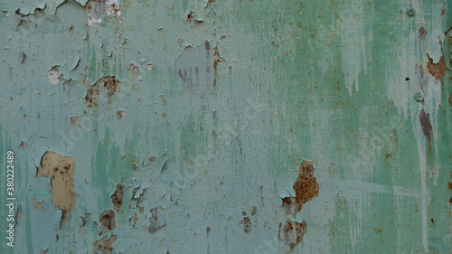 Green rusty and rough metal iron wall plate with flaky coating as background