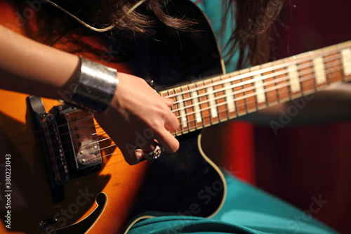 A lady playing guitar indoor photo