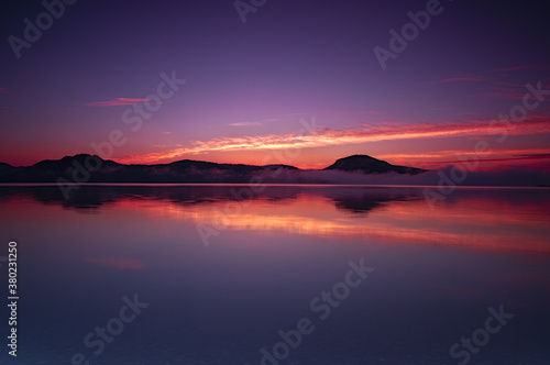 夜明けの空を湖面に映す湖。屈斜路湖、北海道。