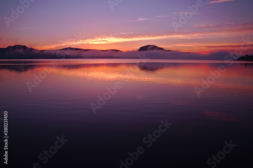 夜明けの空を映す朝の湖。屈斜路湖、北海道。