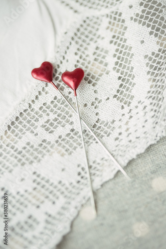 Heart shaped sewing pins on vintage lace photo