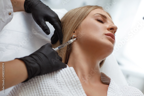 Biorevitalization procedure. Beautician making injection in woman's face