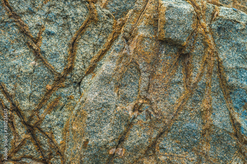 Close up view bright vivid orange brown yellow stone rock shabby cliff cracks texture mountains. Concept of geology, beauty power in nature. Natural summer composition landmark background design