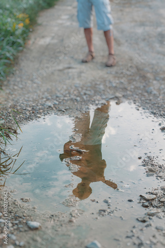 Man's reflection in the puddle holding a guitar photo