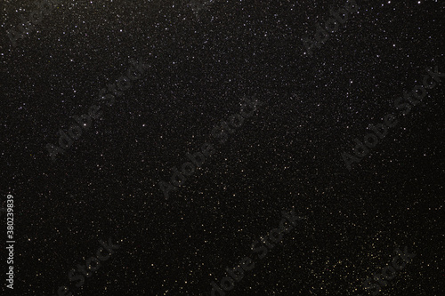 Black texture with micro-relief and glitter similar to the night sky with stars