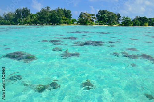 Crystal clear turquoise waters surrounding perfect postcard tropical getaway island photo