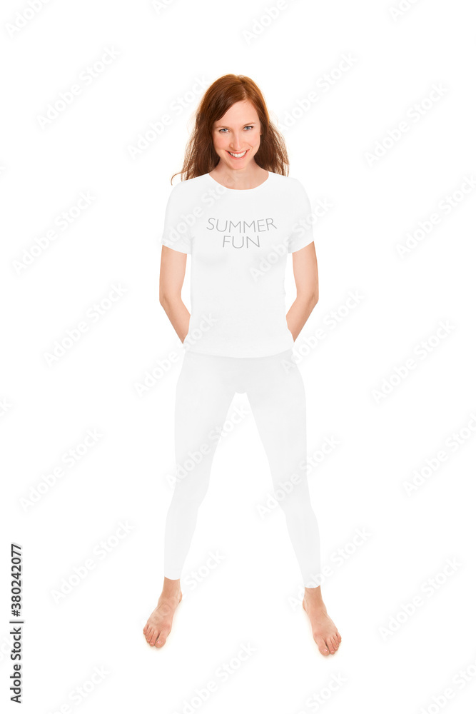 Slim brunette woman wearing white leggings and shirt, summer fun is written on her shirt, full length portrait isolated in front of white studio background Slim brunette woman wearing white leggings and shirt, summer fun is written on her shirt, full length portrait isolated in front of white studio background
