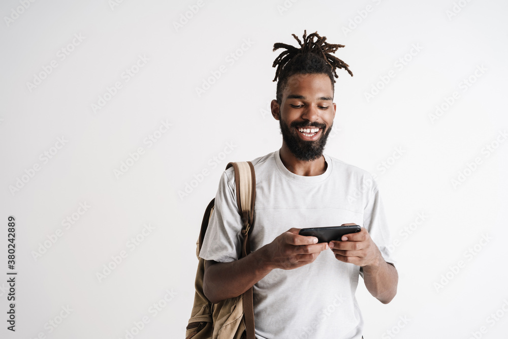 Photo of cheerful african american guy playing online game on cellphone Photo of cheerful african american guy playing online game on cellphone