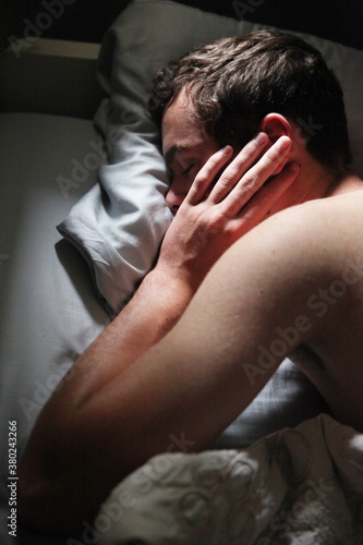Young Man Sleeping with Hand On Side Of Face photo