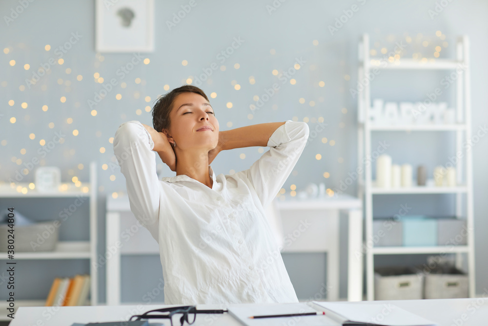 Relaxed woman in her home office enjoying great sense of achievement after finishing all daily tasks - obrazy, fototapety, plakaty 