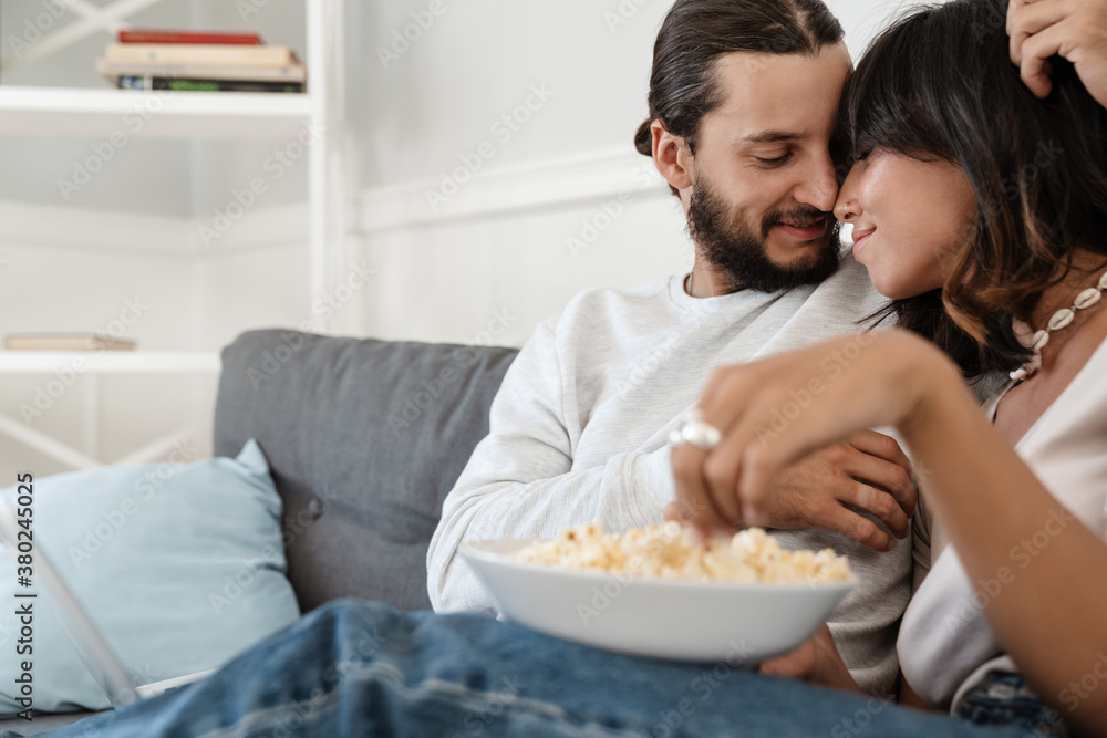 Photo of romantic happy beautiful couple hugging and eating popcorn