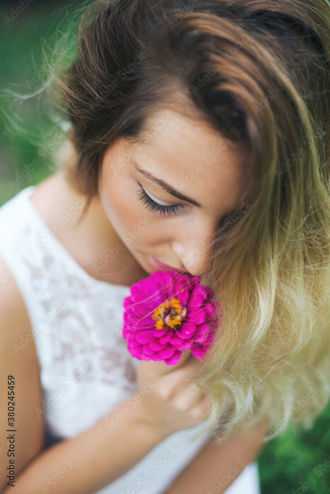Portrait of a woman smelling flower outdoors Portrait of a woman smelling flower outdoors