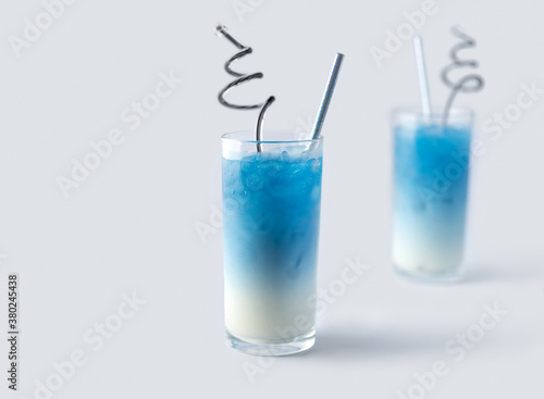 Summer refreshing beverage blue butterfly pea latte in glass on white background