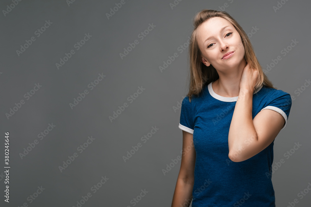 Angry blonde is looking into the camera with a piercing gaze. Studio shot gray background. Facial expression concept Angry blonde is looking into the camera with a piercing gaze. Studio shot gray background. Facial expression concept