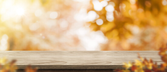 Autumn background.Empty old rustic wood table with blur forest tree with sunlight,Autumn fall backdrop, banner for product display for advertise on online,thanksgiving concept