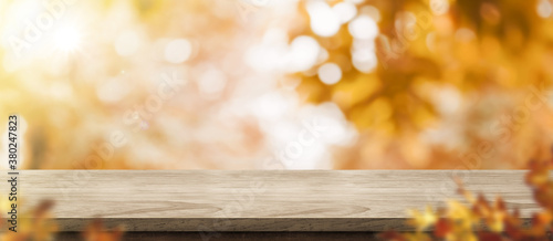 Fototapeta Naklejka Na Ścianę i Meble -  Autumn background.Empty old rustic wood table with blur forest tree with sunlight,Autumn fall backdrop, banner for product display for advertise on online,thanksgiving concept