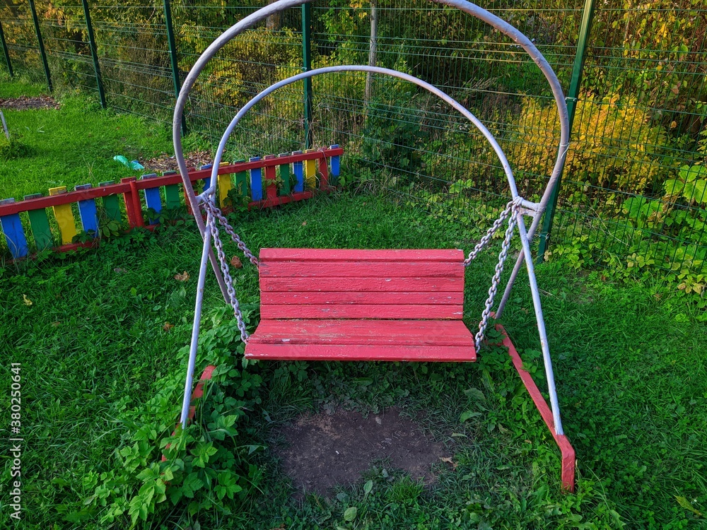 old children's swing in the kindergarten in the autumn season