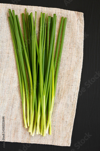 Raw Green Onions on a black background, top view. Flat lay, overhead, from above. Copy space.