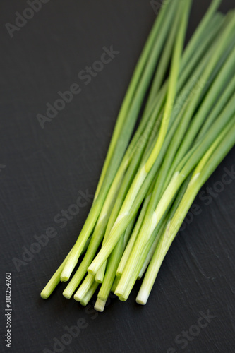 Raw Green Onions on a black background  side view.