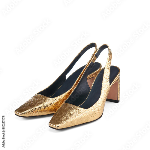 Beautiful elegant open summer women's shoes made of Golden leather with high heels, isolated on a white background with shadow. Summer women's shoes. View from above at an angle.