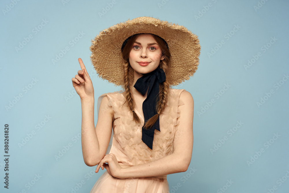 Romantic girl in a straw hat on a gray background and a beige sundress black ribbon emotions model